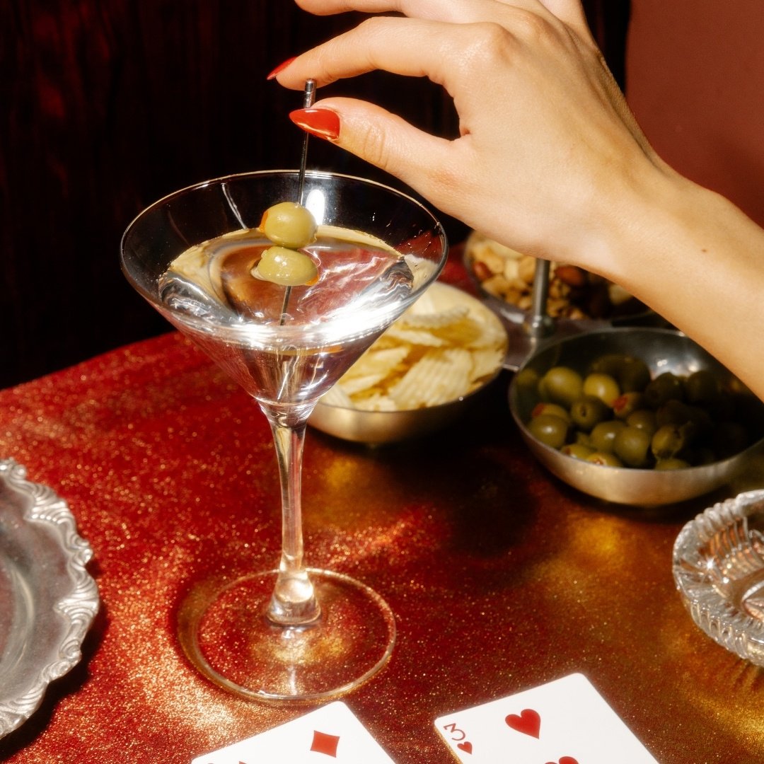 lady holding her olive stem from her martini glass 