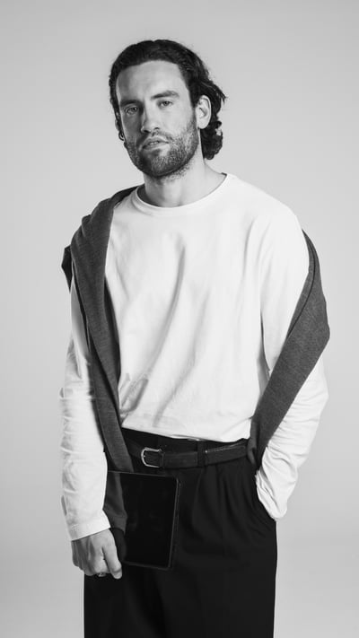 white male in white tshirt with medium length hair and a jersey around his neck 