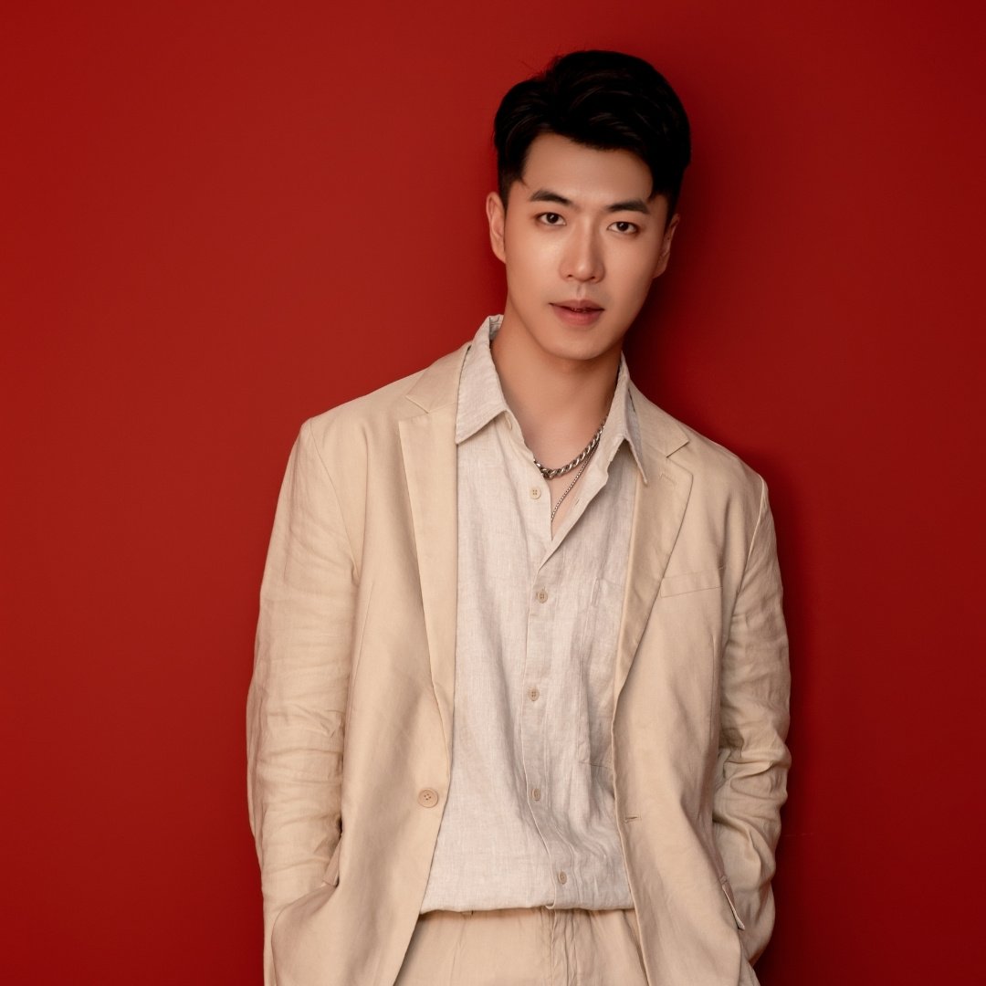 Asian male model in a beige suit and linen shirt with short hair