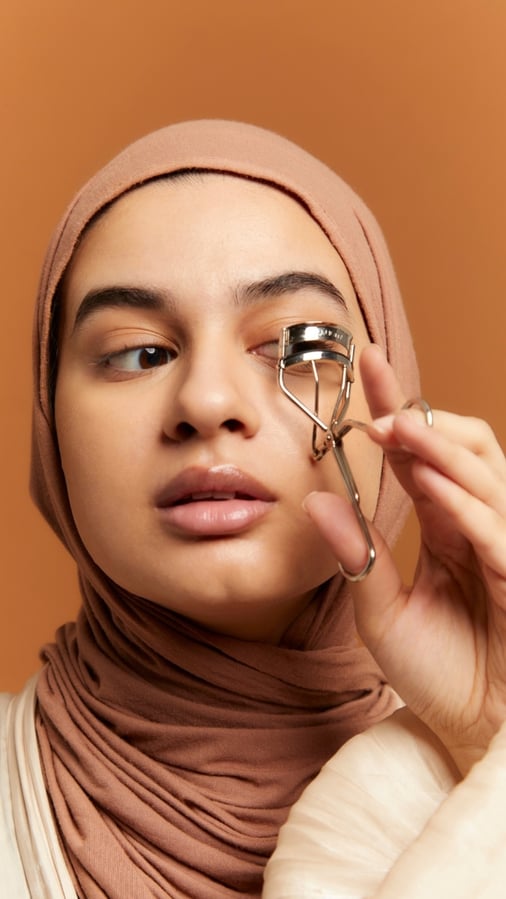 woman in a hijab doing makeup