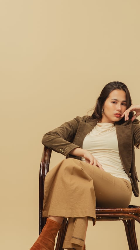 girl sitting on a chair, face angled sideways but looking at the camera 