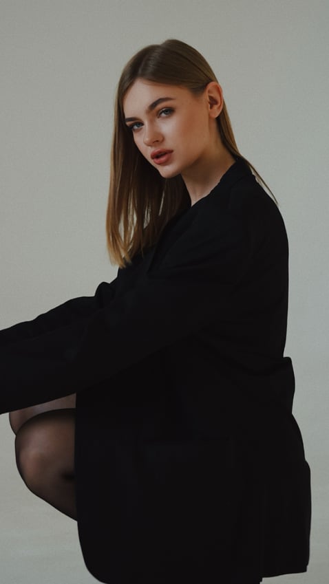 girl crouching down sideways with her face angled towards the camera