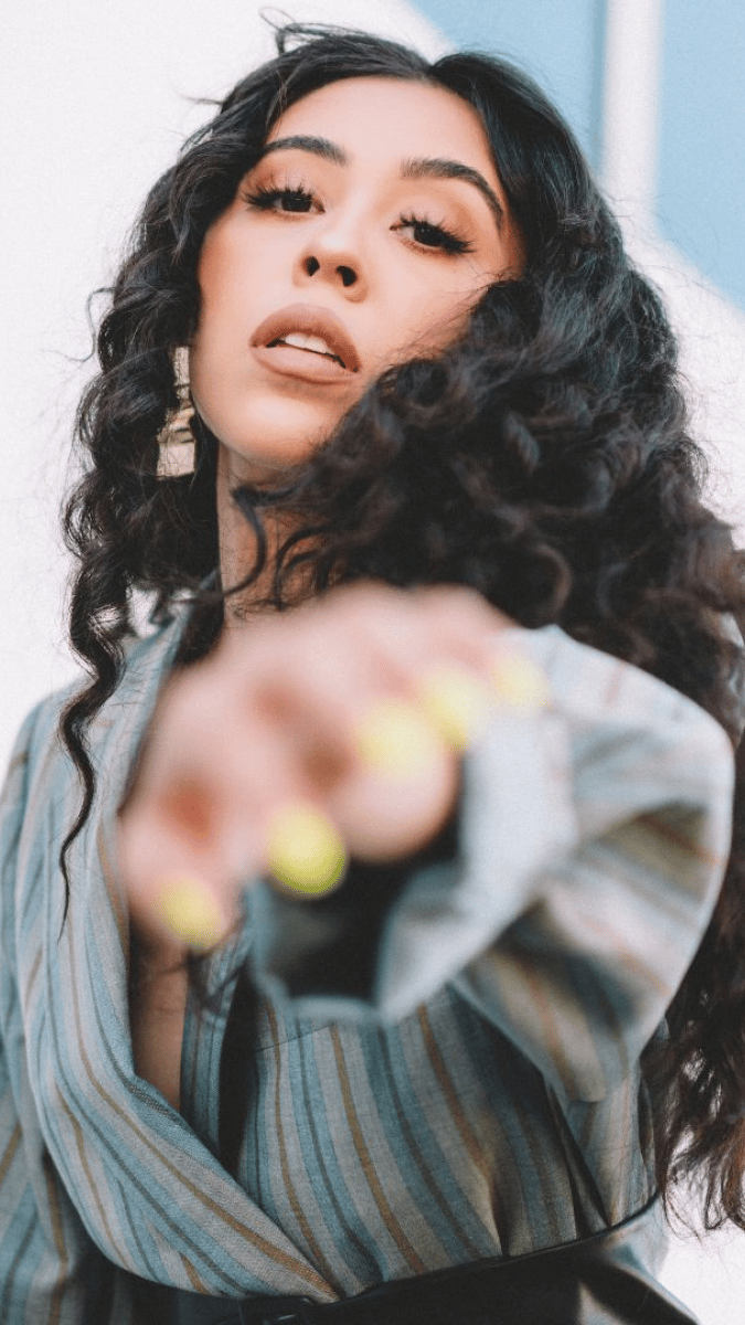 curly, dark haired woman reaching for the camera