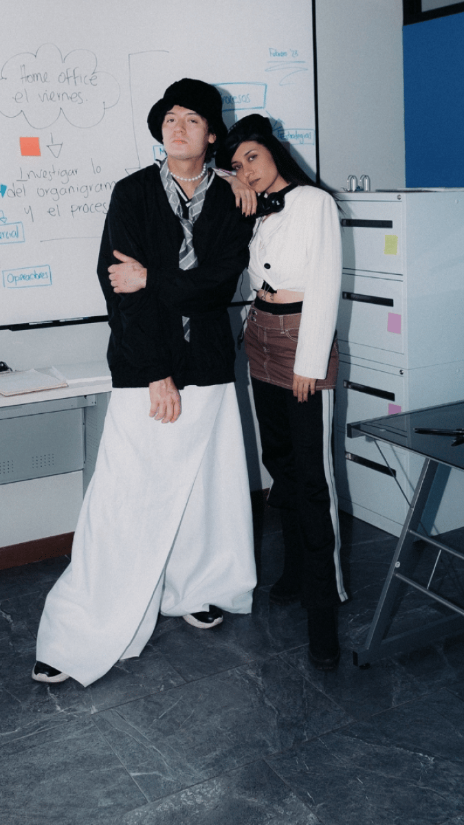 A male and female model standing in a classroom, both wearing funky fashion statements 