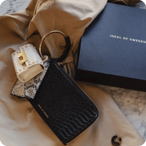 Image of a black card holder and a black Ideal of Sweden box