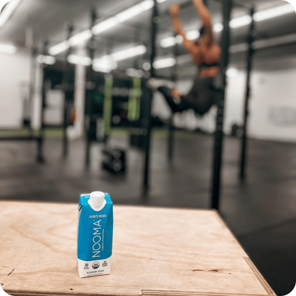 Nooma drink on wooden bench in the gym