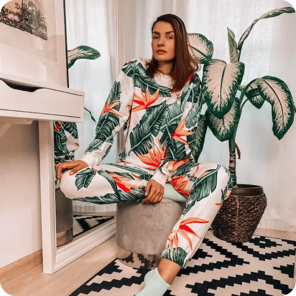 A woman with brown hair in a green and orange floral Onepiece outfit