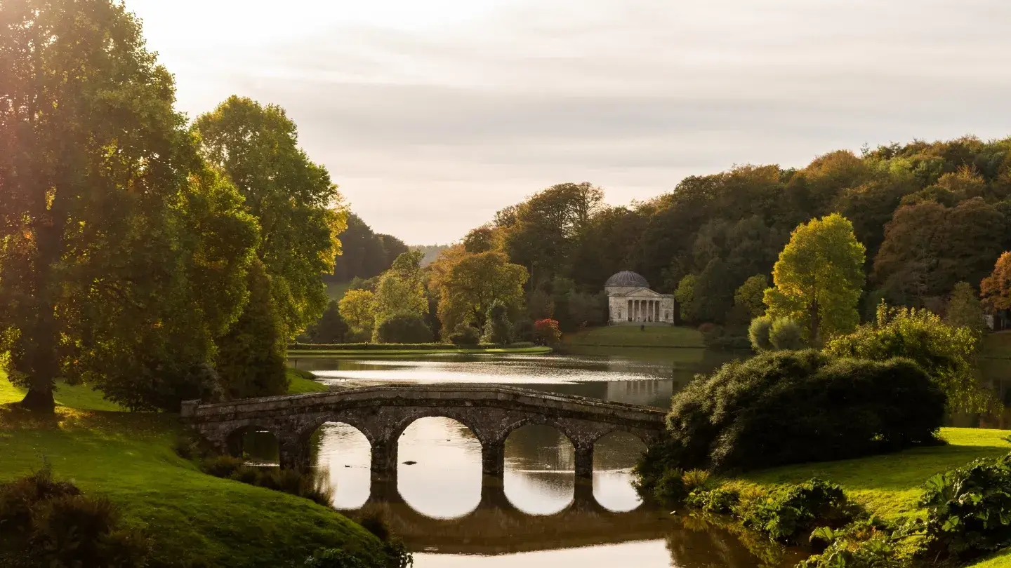 countryside view with a lake and a bridge crossing over